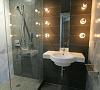 A gentleman’s bathroom incorporates marble and innovative modern lighting. Designer Cb Miles.